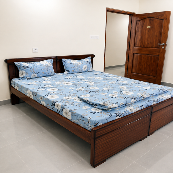 Bedroom, modern bedroom, master bedroom, double bed, wooden bed, wooden furniture, dark wood, wooden headboard, wooden door, blue bedding, floral bedsheet, floral bedding, blue bedspread, patterned bedding, floral print, decorative pillows, bedroom decor, cozy bedroom, elegant bedroom, traditional furniture, contemporary interior, residential interior, apartment bedroom, sleeping area, comfortable bed, king size bed, spacious bed, storage bed, wooden storage drawers, built-in storage, neutral walls, cream walls, tiled floor, gray floor tiles, minimalist room, clean interior, simple decor, warm wood tones, natural wood, polished wood, bedroom furniture, home interior, indoor photography, modern home, functional design, cozy home, stylish bedroom, floral home decor, blue and white decor, wooden craftsmanship, relaxing space, furnished bedroom.